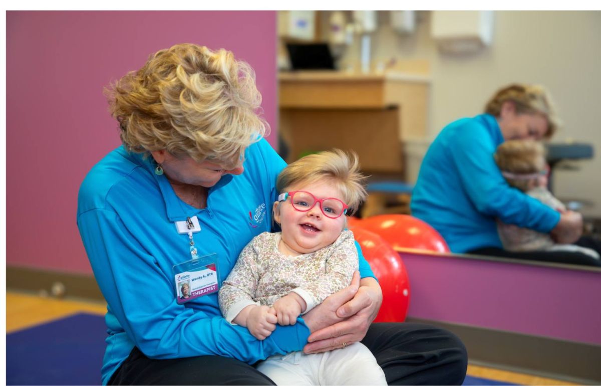 Elliana smiles as she's held by Gillette occupational therapist Wendy Aeling