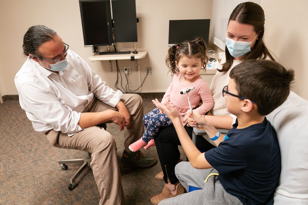 Rose, Xavier and Carrie Menke meet in a clinic room with Gillette neurologist, Randal Richardson.
