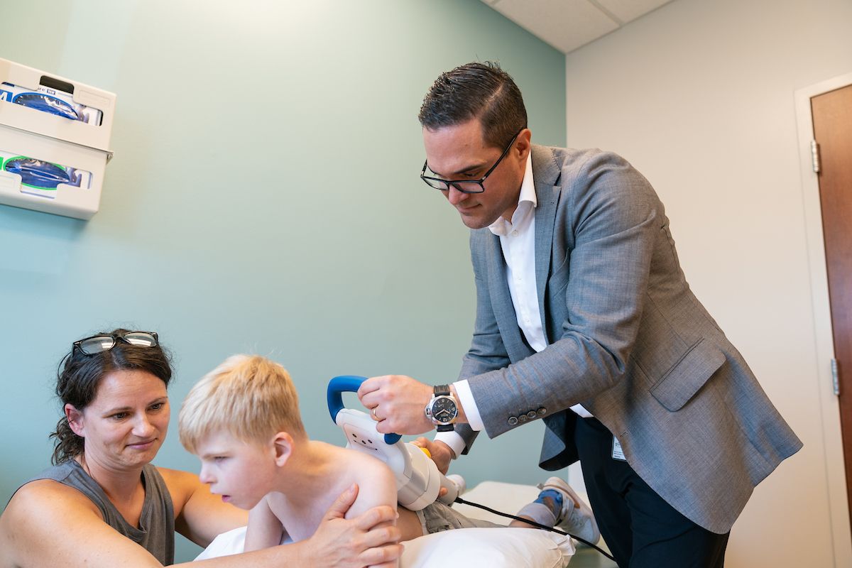 Gillette pediatric spine surgeon, Eduardo Beauchamp, MD, makes an adjustment to the magnetically driven growing rods, known as MAGEC rods, in Zayne's spine.