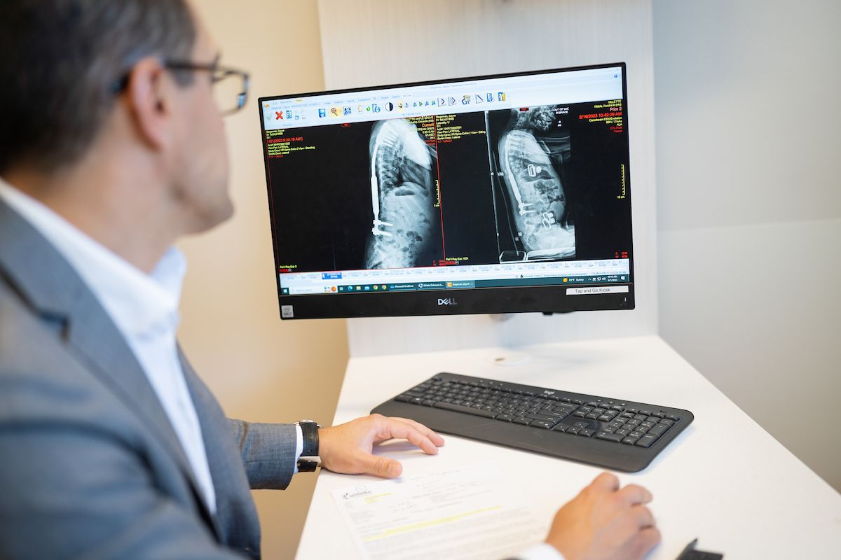 Gillette pediatric spine surgeon, Eduardo Beauchamp, MD, looks at x-ray images of a spine.