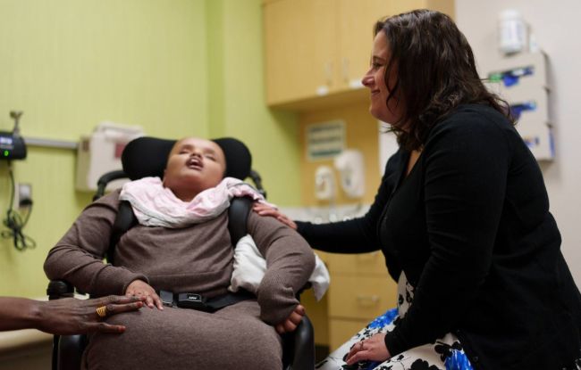 Janelle Pasch-Berglund visits with patient Yusra Abdalla