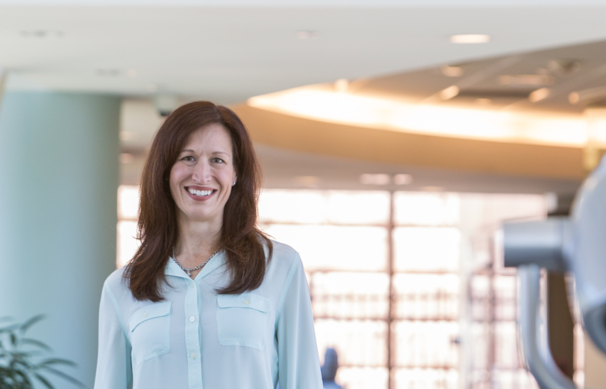 Marcie Ward, MD, is a nationally recognized pediatric rehabilitation medicine physician at Gillette Children's is standing in the Gillette skyway.